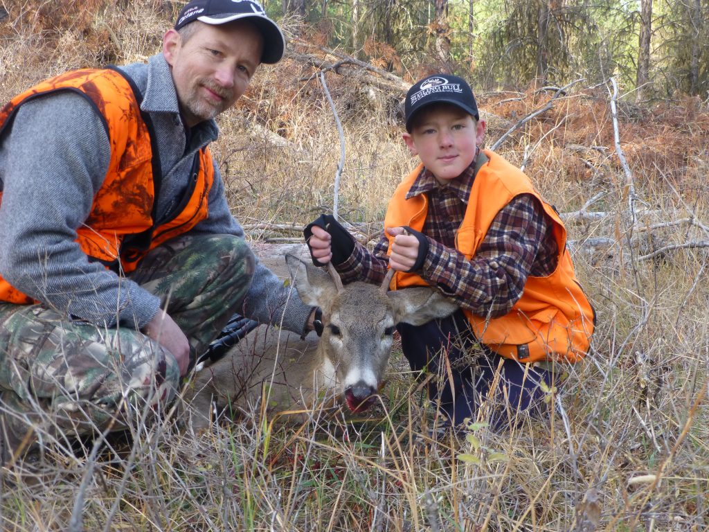 Bill Smith with his son and the buck they shot, hunter safety eduction concept. 