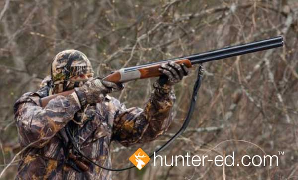 A hunter points a rifle safely, hunter safety concept.
