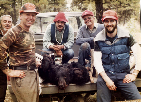A group of hunters around a deceased bear in a truck, bear encounters concept. 