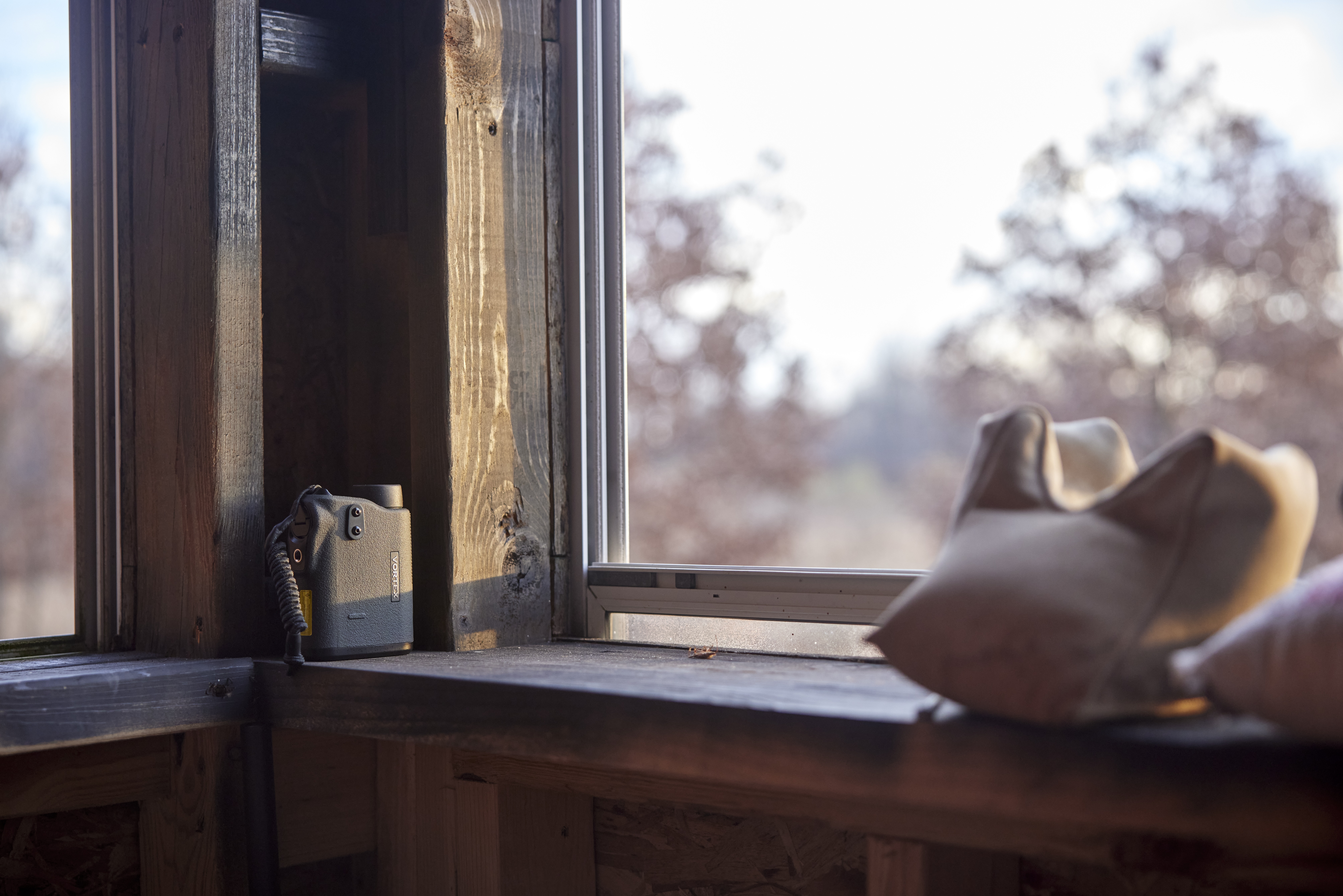 A hunting scope next to a window, hunting gear concept.