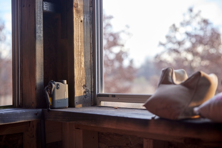 A hunting scope next to a window, hunting gear concept. 