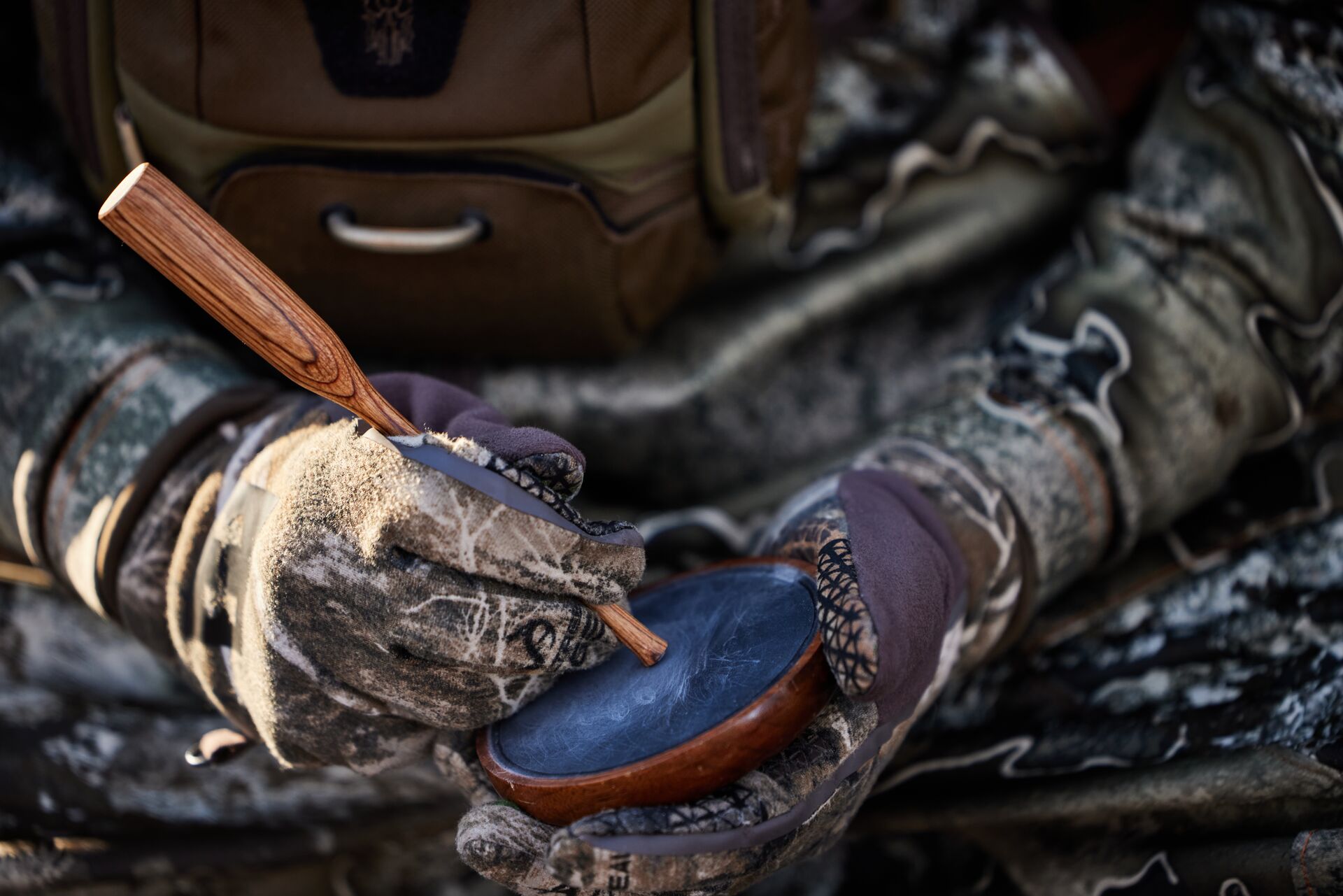 Close-up of hunter using a turkey slate call. 