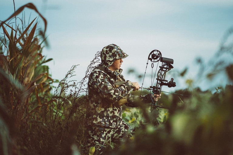 A hunter in camo draws a bow, hunting in Oklahoma concept. 