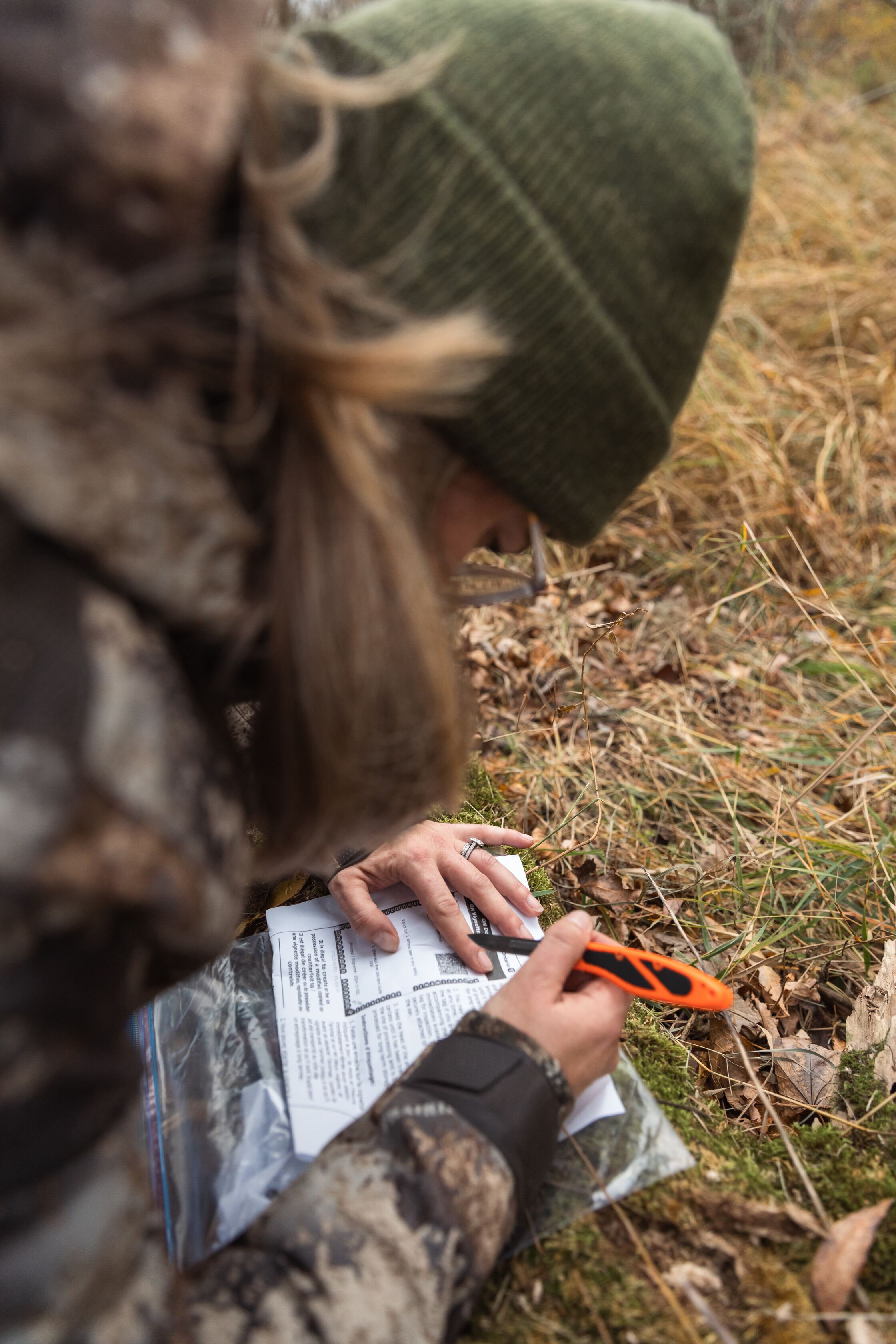 A hunter marks a deer tag before field dressing.
