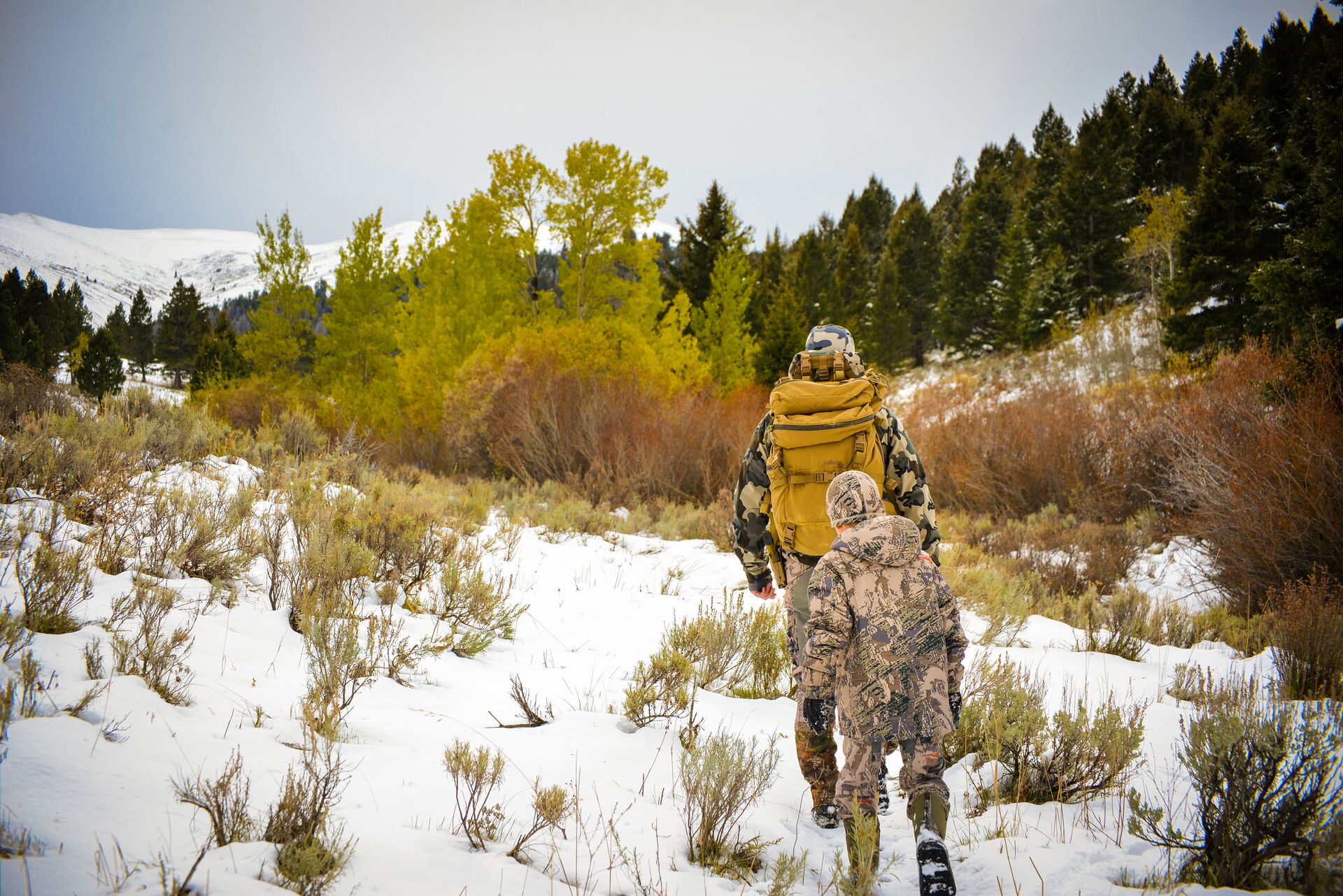 Two hunters on a mountain with snow on the ground, Colorado hunting concept.