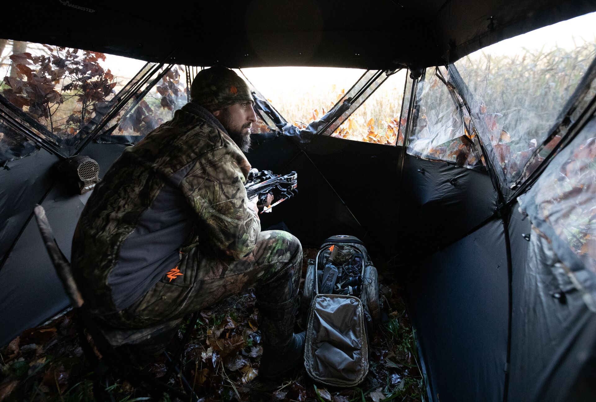 Hunter looks out from hunting blind, how to get into hunting concept. 