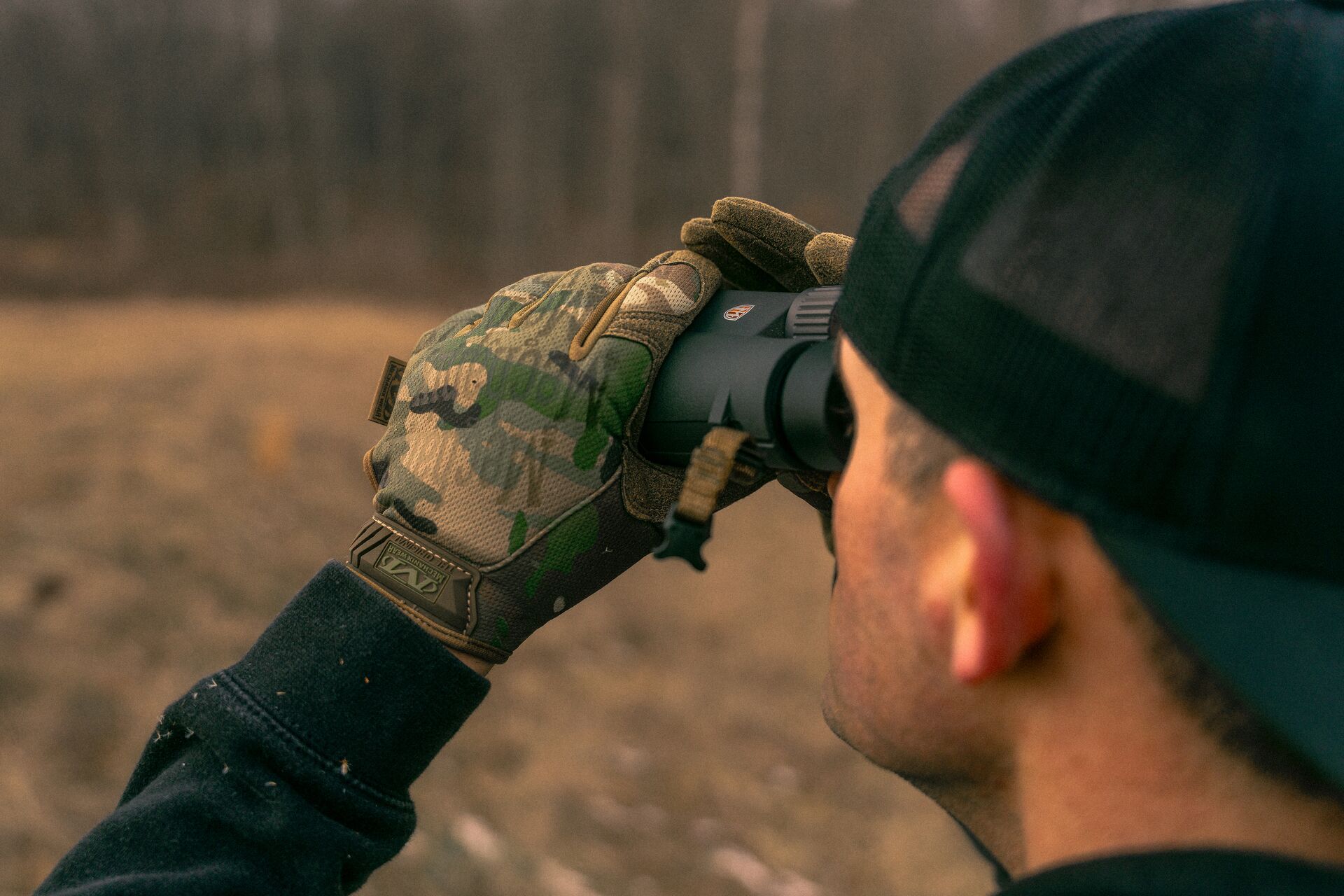 Hunter uses binoculars, scouting for beginner hunting concept. 