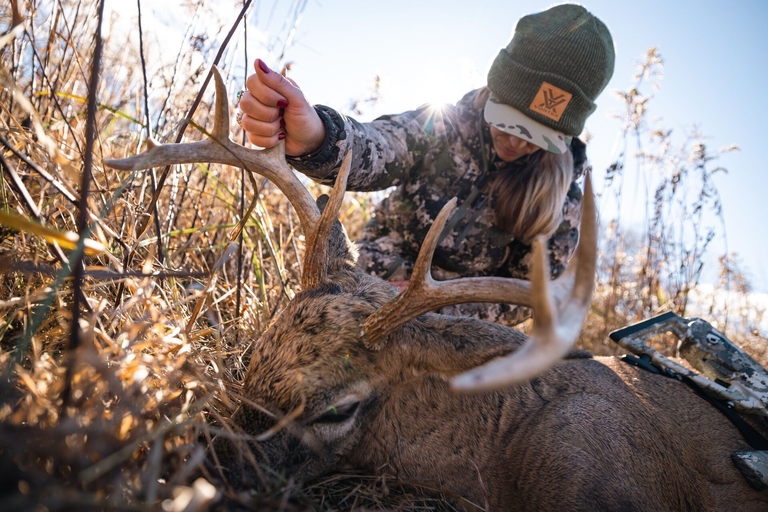 Woman with deer on the ground after a hunt, what is deer open season concept. 