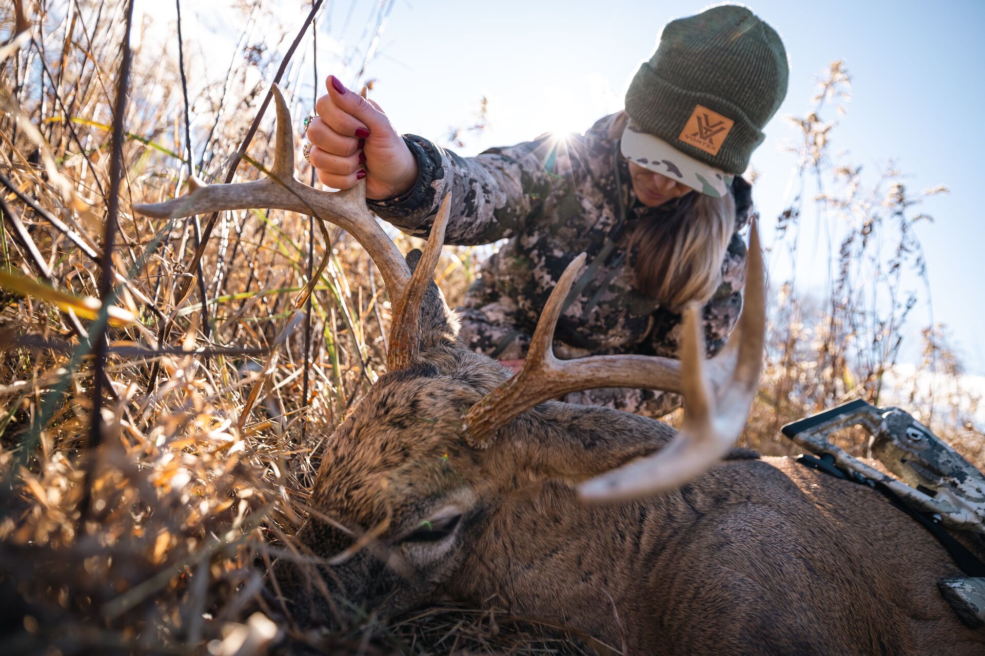 Woman with deer on the ground after a hunt, what is deer open season concept. 