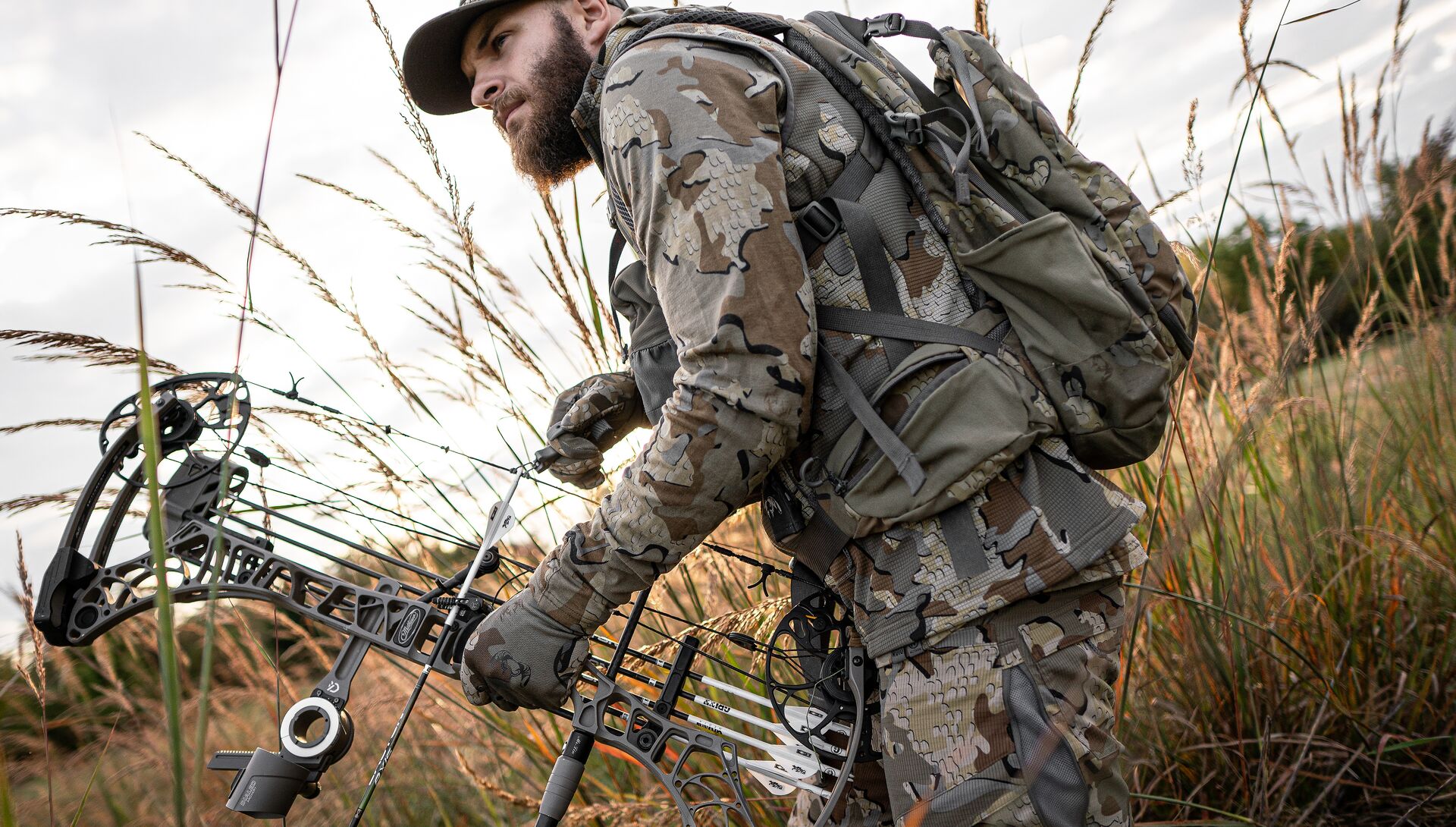 Hunter in camo with bow in field, what hunting season is open right now concept. 