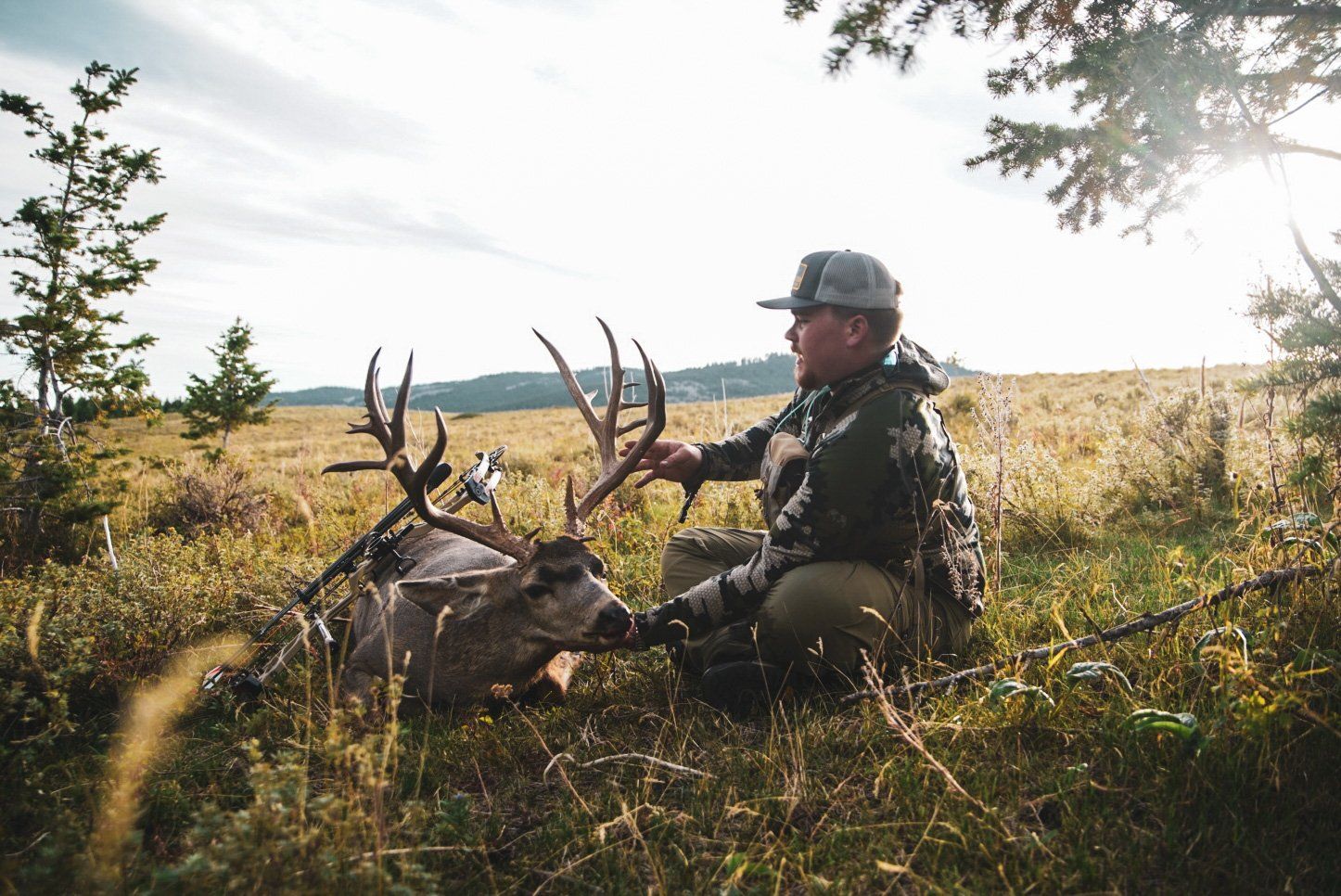 Hunter with mule deer buck after hunt.