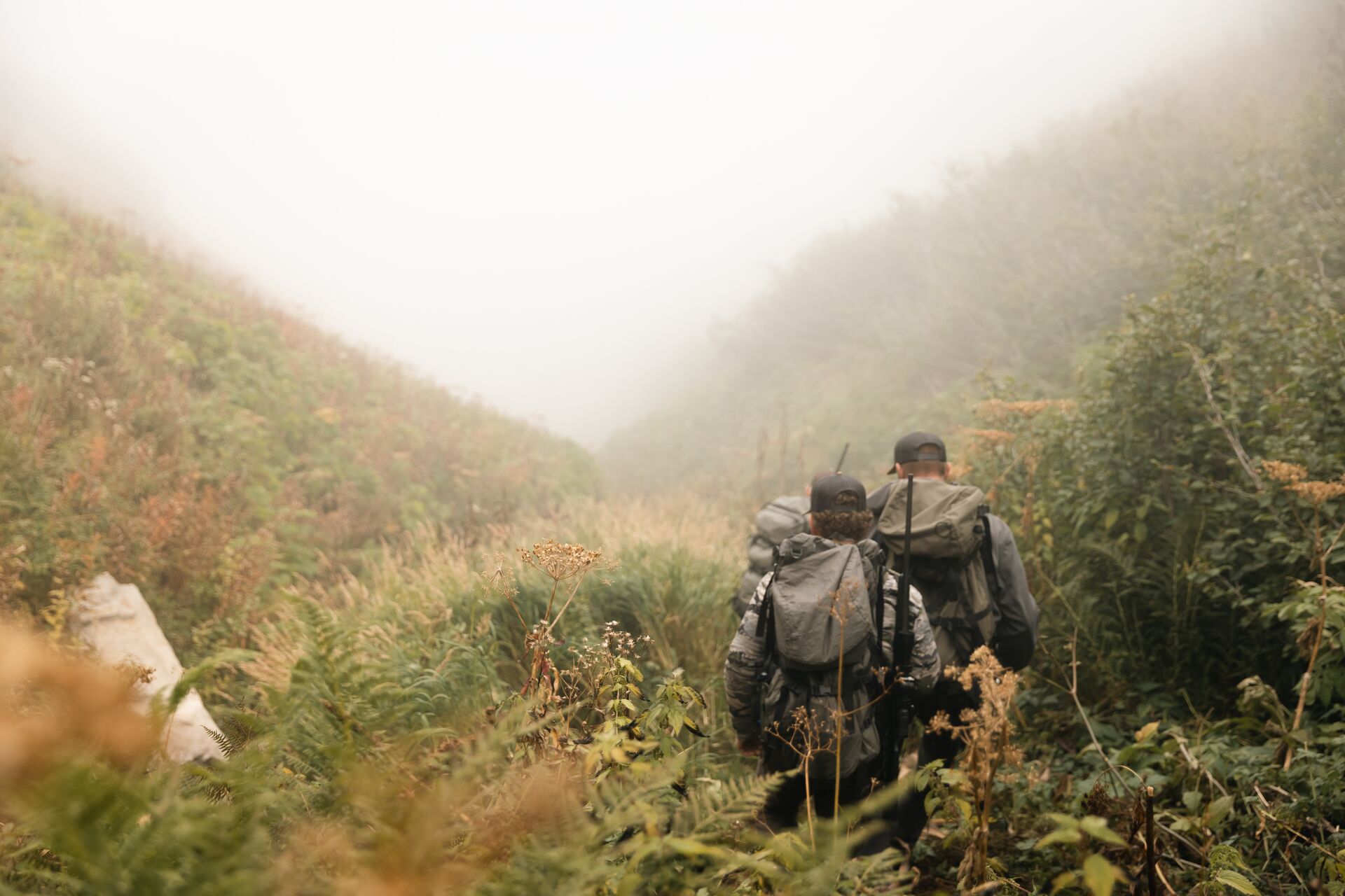 Hunters hiking with packs, what should every prepared hunter carry for outdoor emergencies concept.