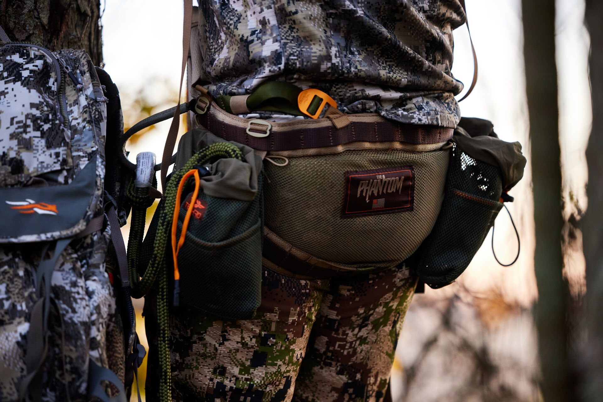 Close-up of a hunter with gear in a tree stand.