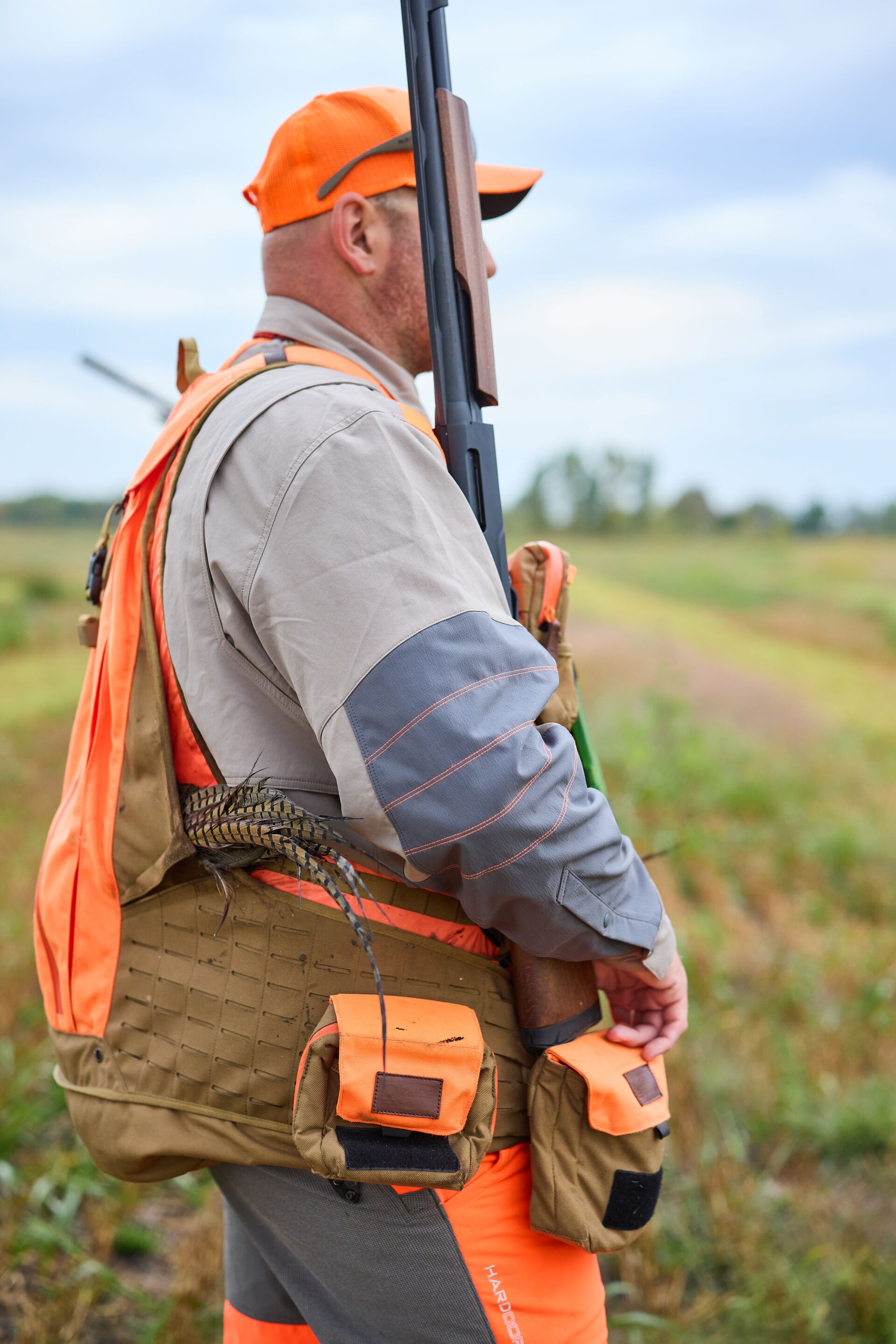 Hunter with shotgun and upland hunt gear.