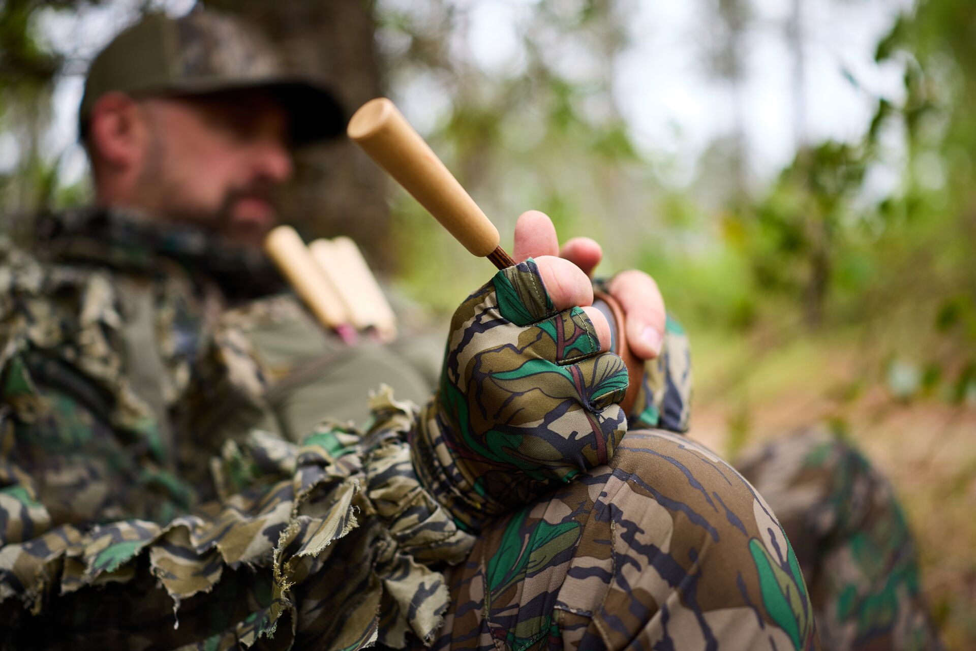 Close-up of a hunter using a slate turkey call in the woods. 