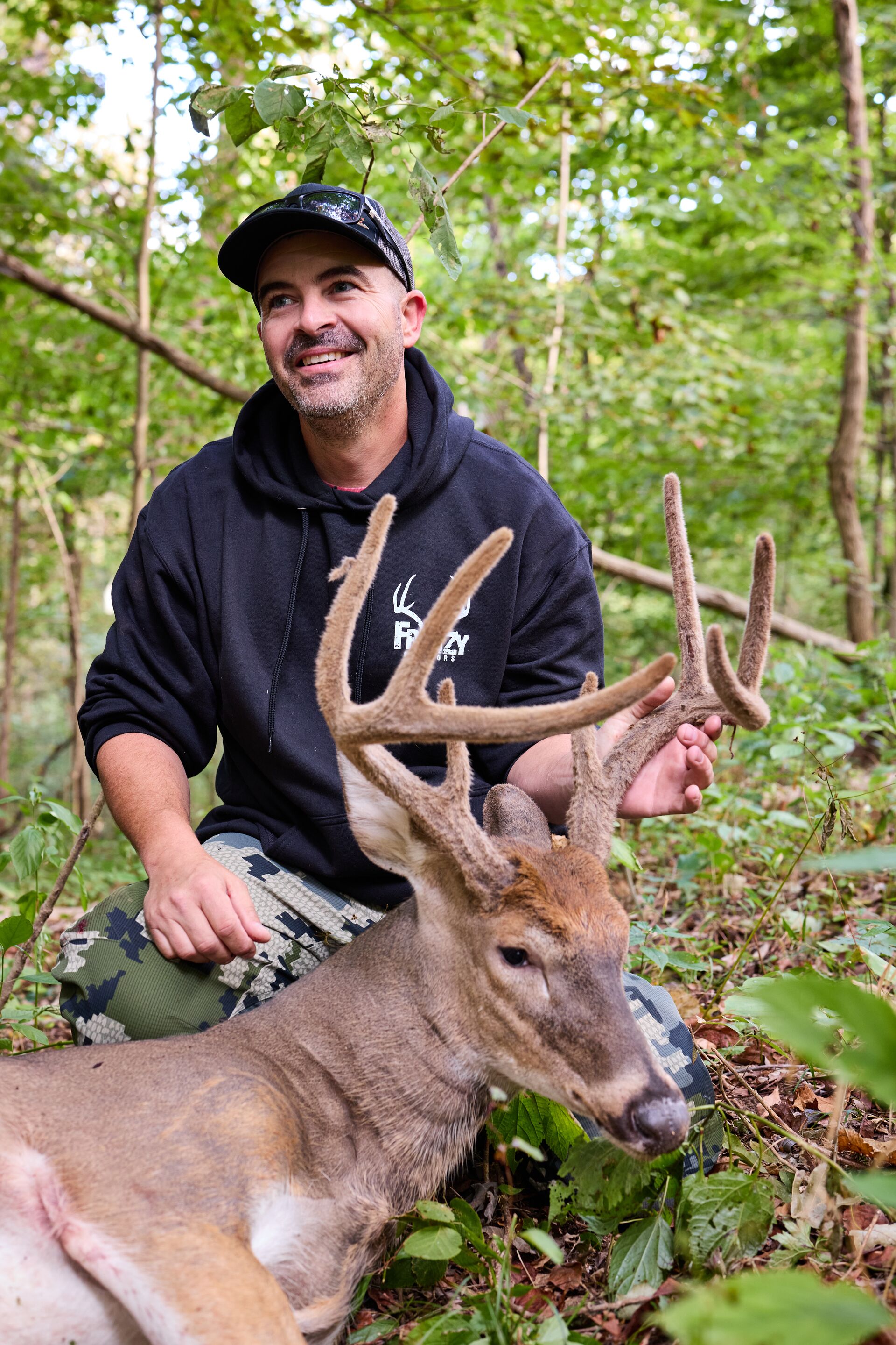 Hunter shows off buck deer after hunt, cost to get a California hunting license concept. 