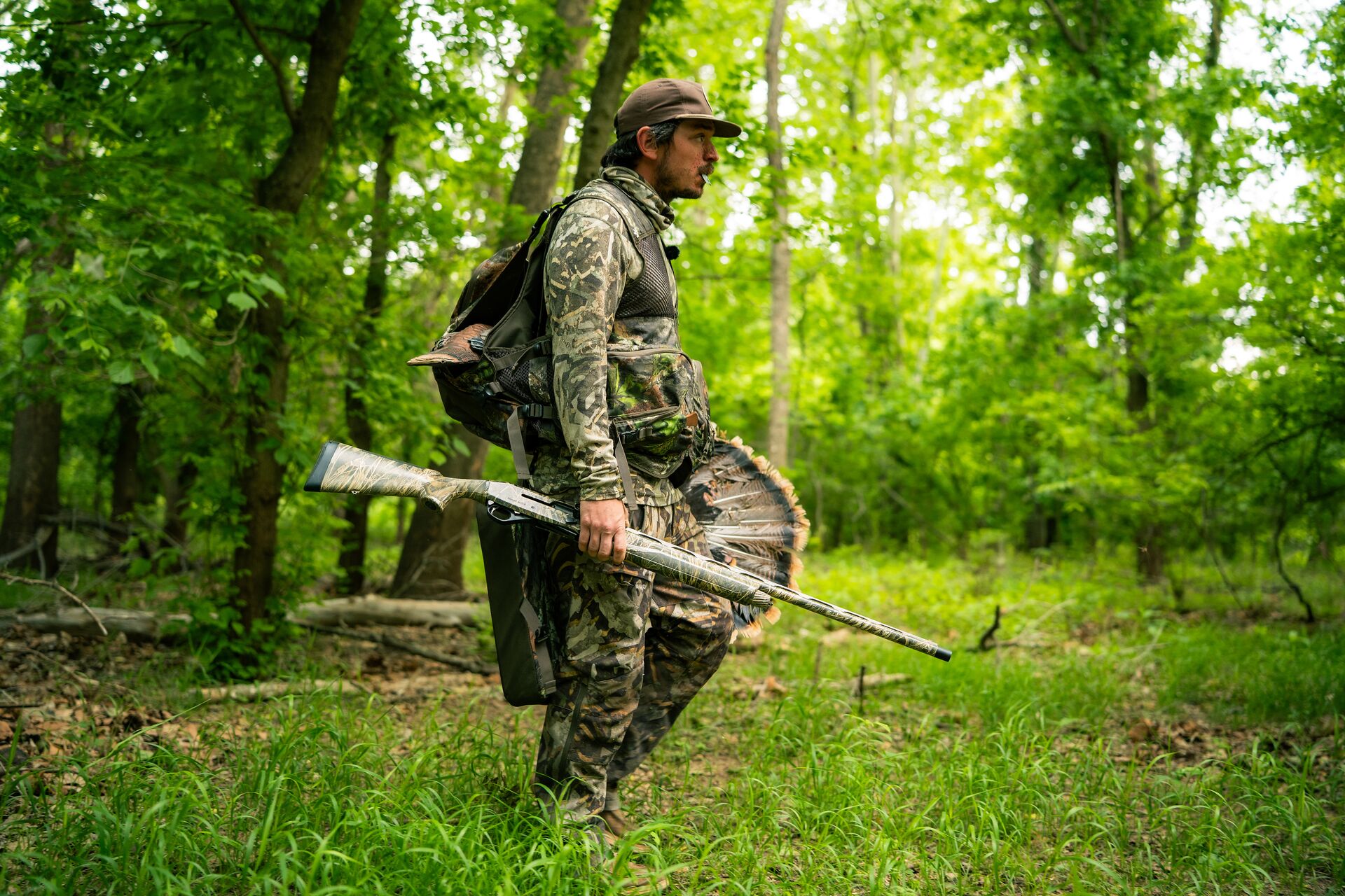 Hunter walks in woods with firearm, how much does it cost to get an Indiana hunting license concept. 