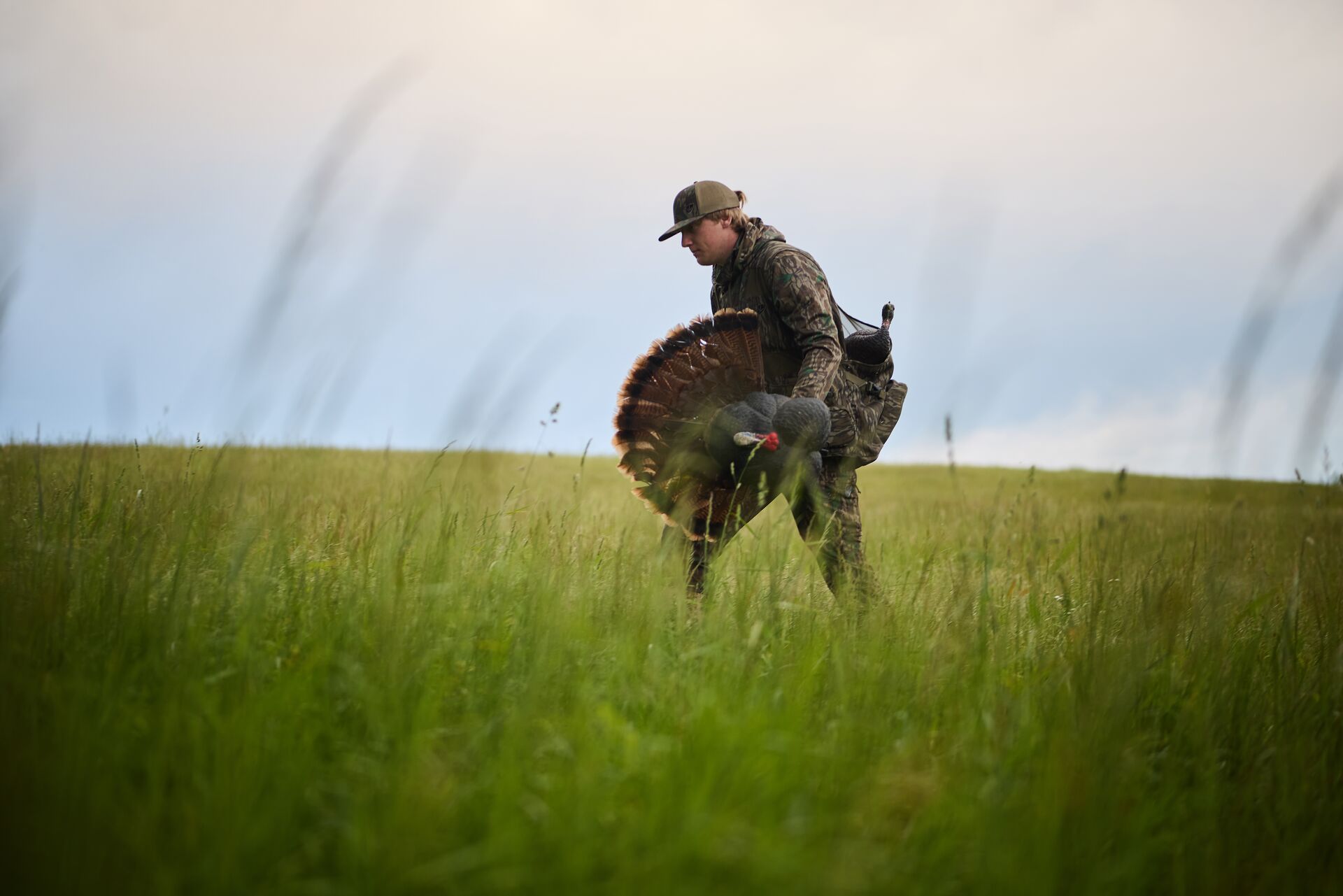 Hunter with gear for turkey hunt in field. 
