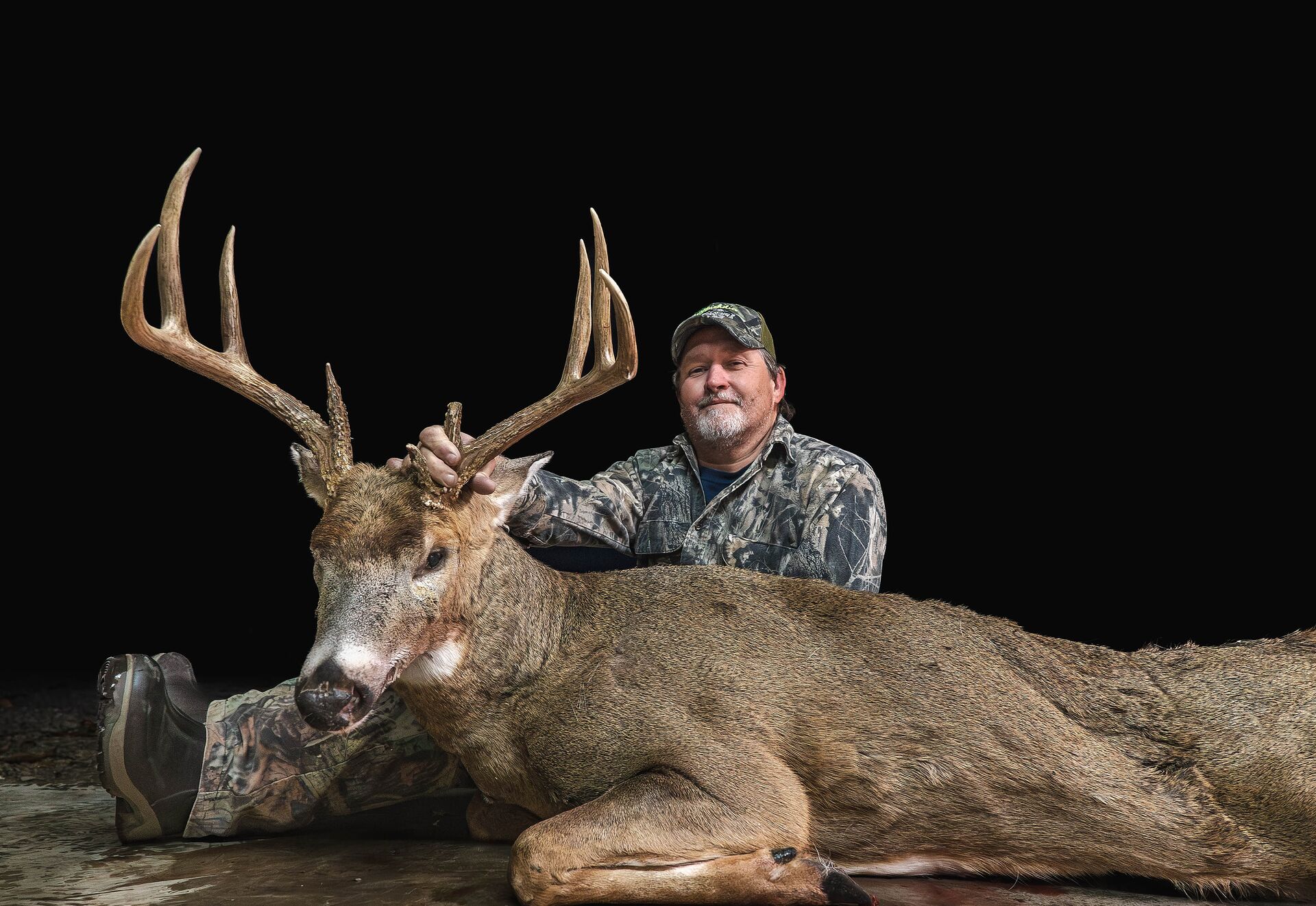 Hunter shows off large buck deer after hunt, how much does it cost to get a Georgia hunting license concept. 