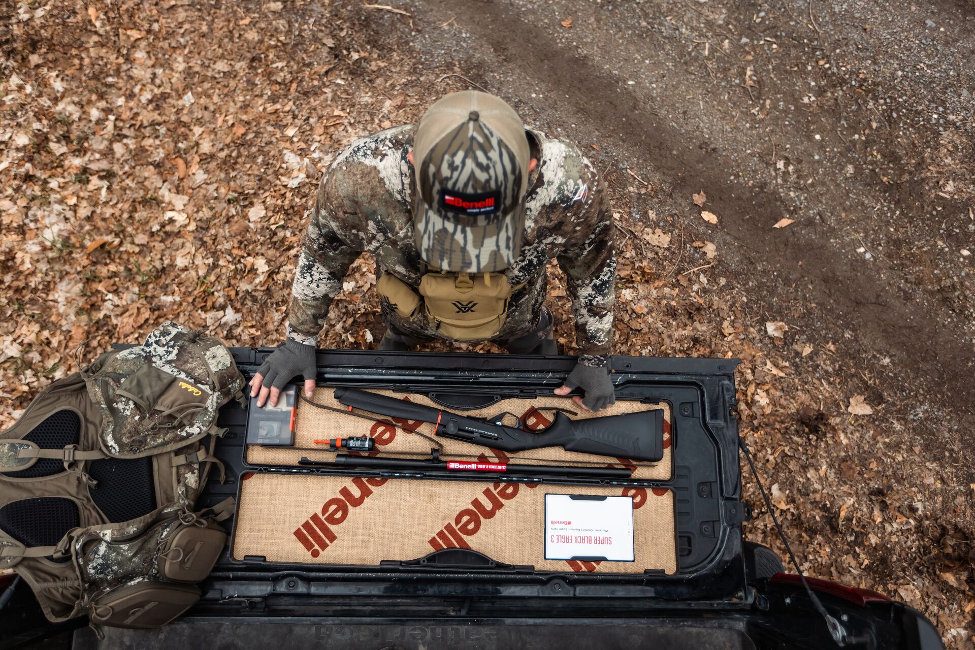 Overhead view of hunter with open gun case, Alabama hunting license cost concept.