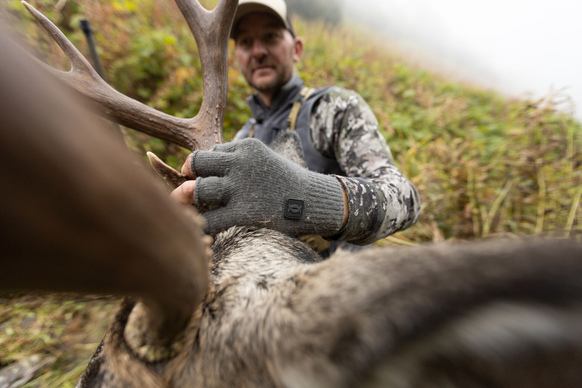 Close-up of hunter with buck antlers after hunt, Arizona hunting license cost concept.