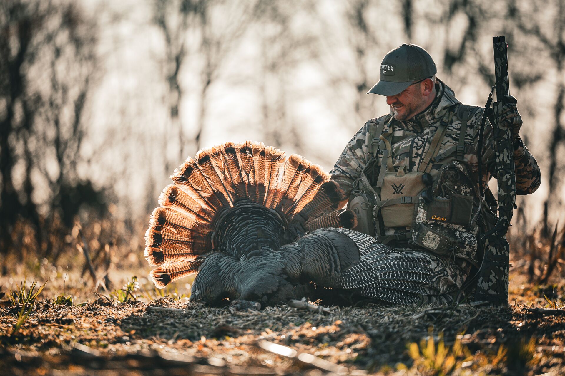 Hunter sits with turkey and shotgun after hunt, how much does an Missouri hunting license cost concept.