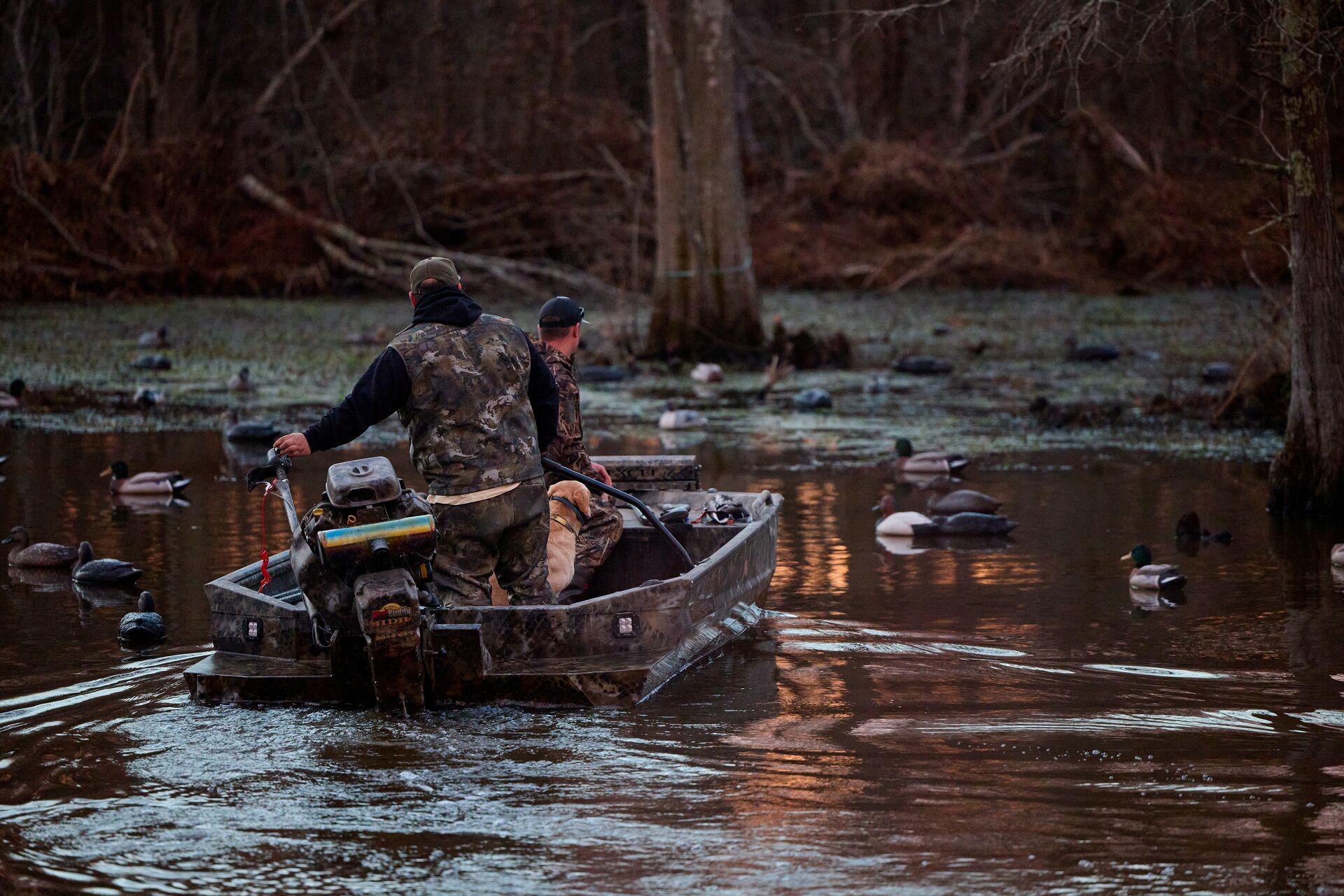 Waterfowl hunters on a boat in the water, Louisiana hunting license cost concept. 
