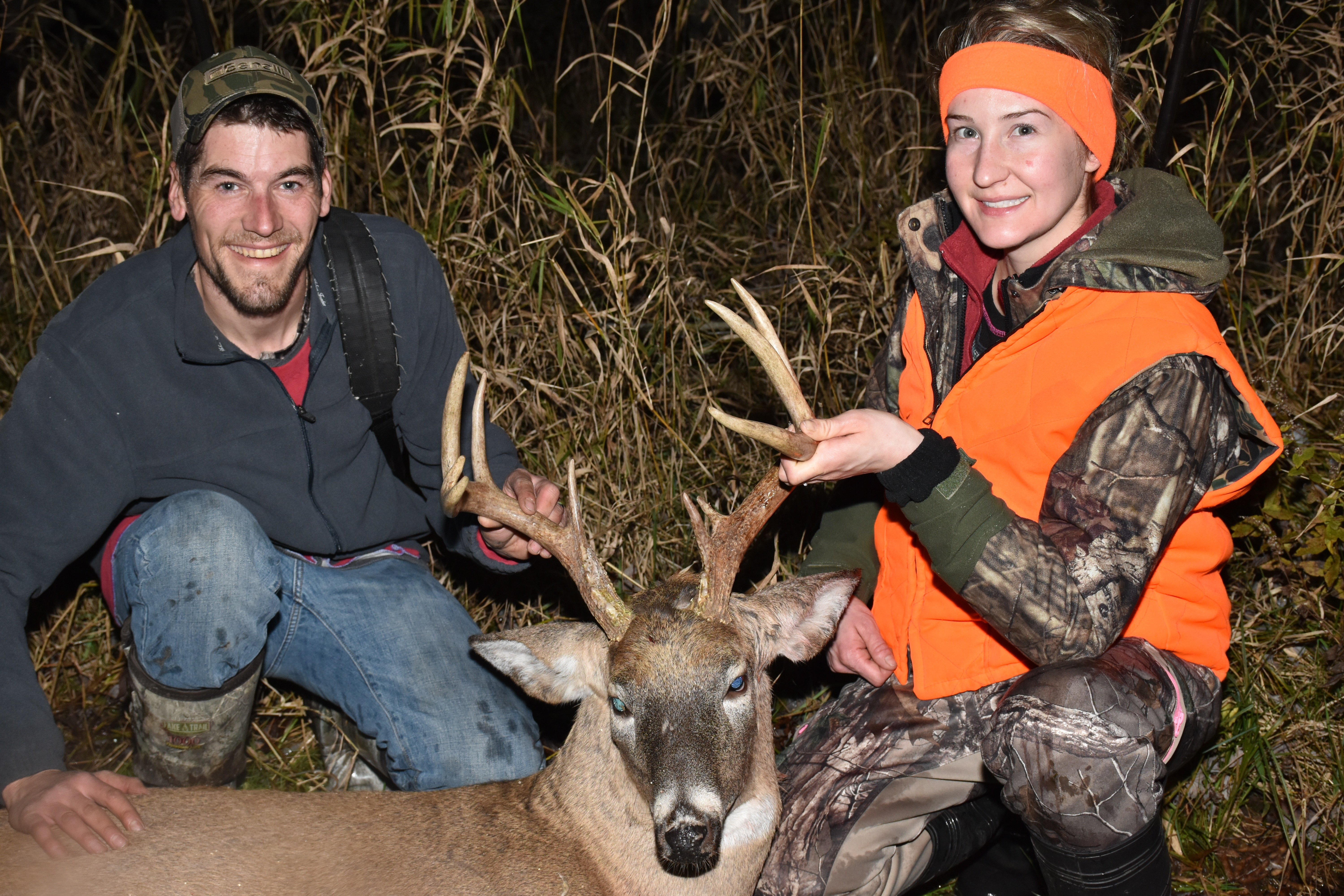 A woman with a man and her deer kill, busting anti-hunting myths concept.