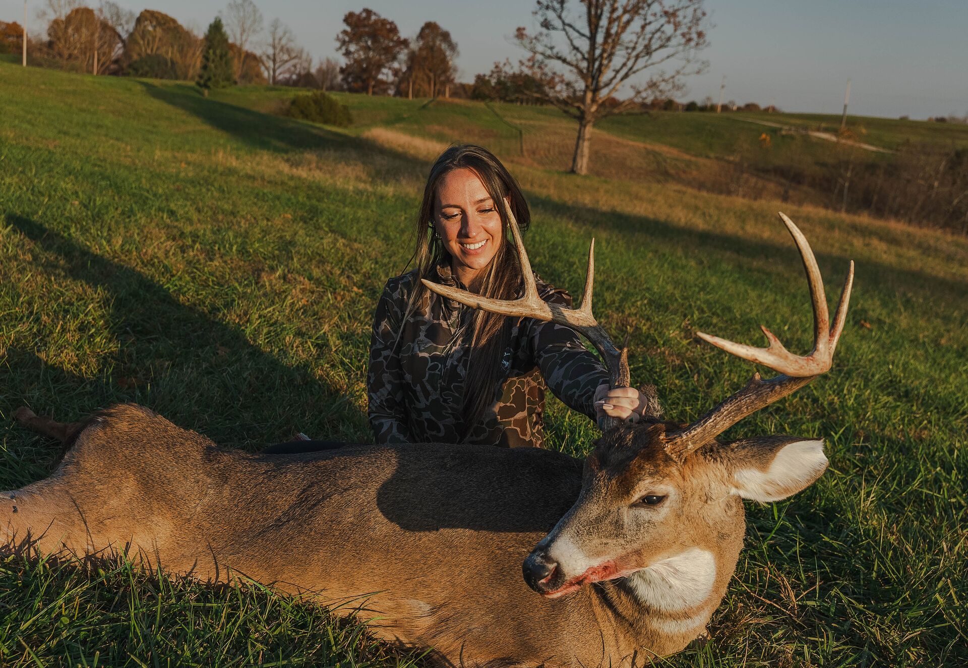 Female hunter with buck deer after hunt, how to get a hunting license concept. 