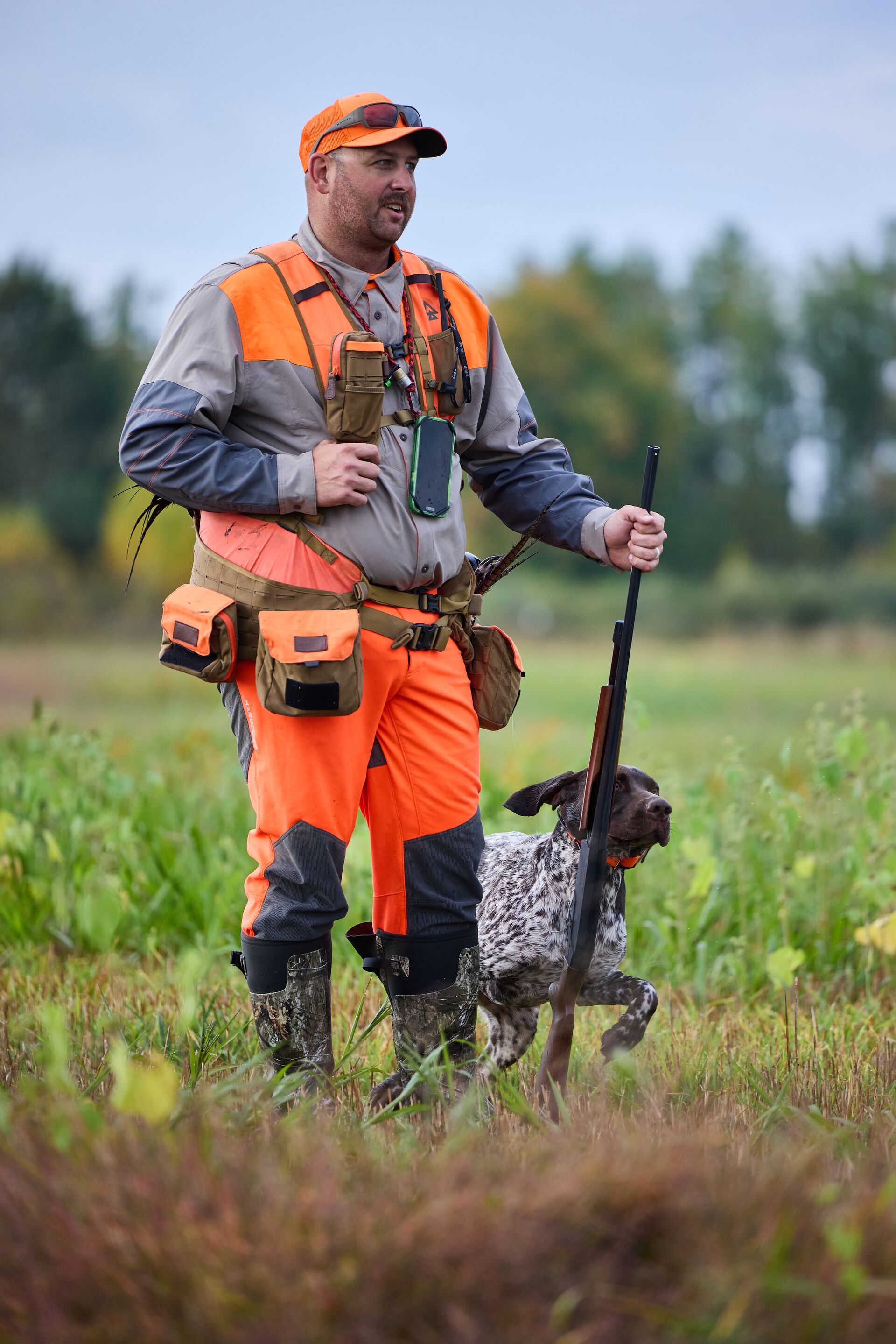 Hunter in blaze orange with dog for upland hunt, get a hunting license concept. 