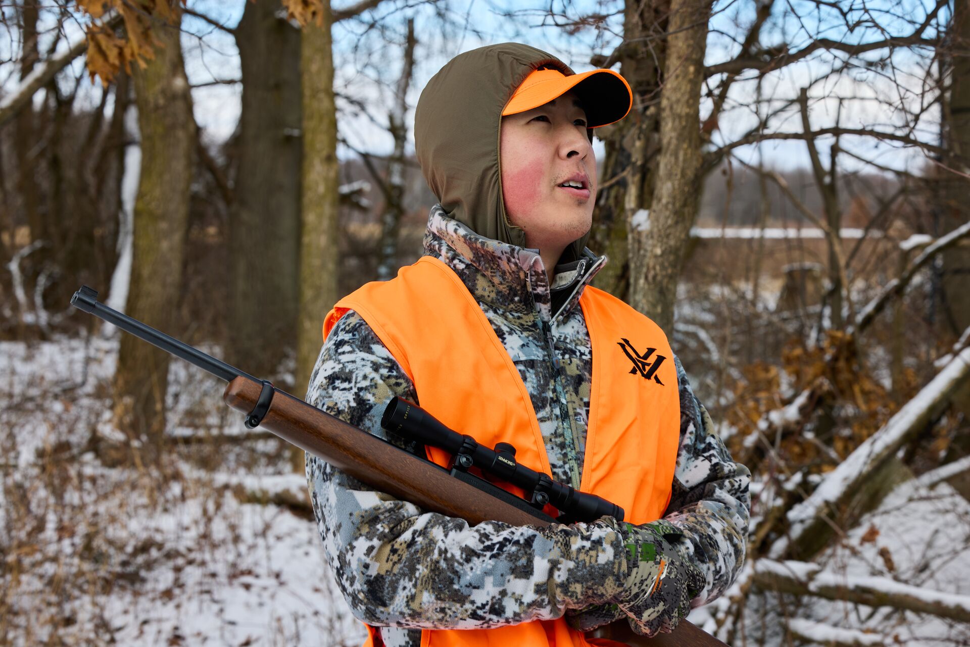 Hunter in orange vest with firearm, how do i get a hunting license concept. 
