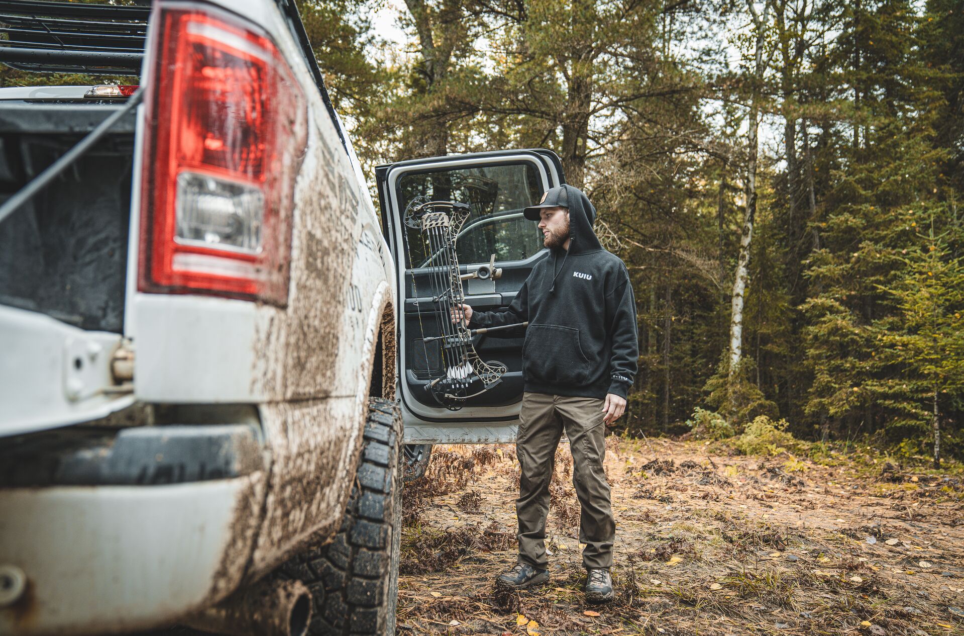 Hunter with bow next to truck, how to buy a hunting license online concept. 