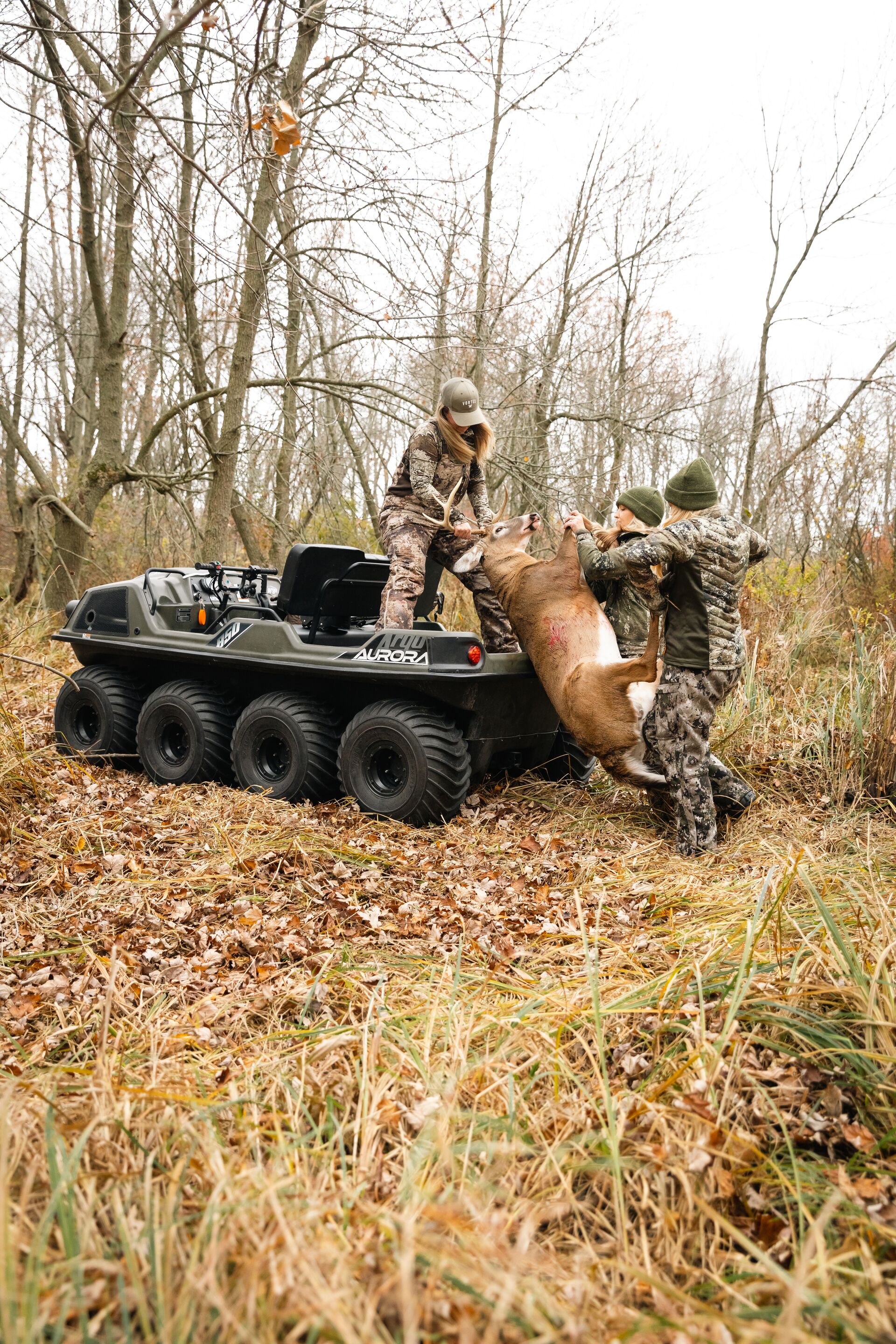 Female hunters move deer onto ATV, take a hunter safety course concept. 