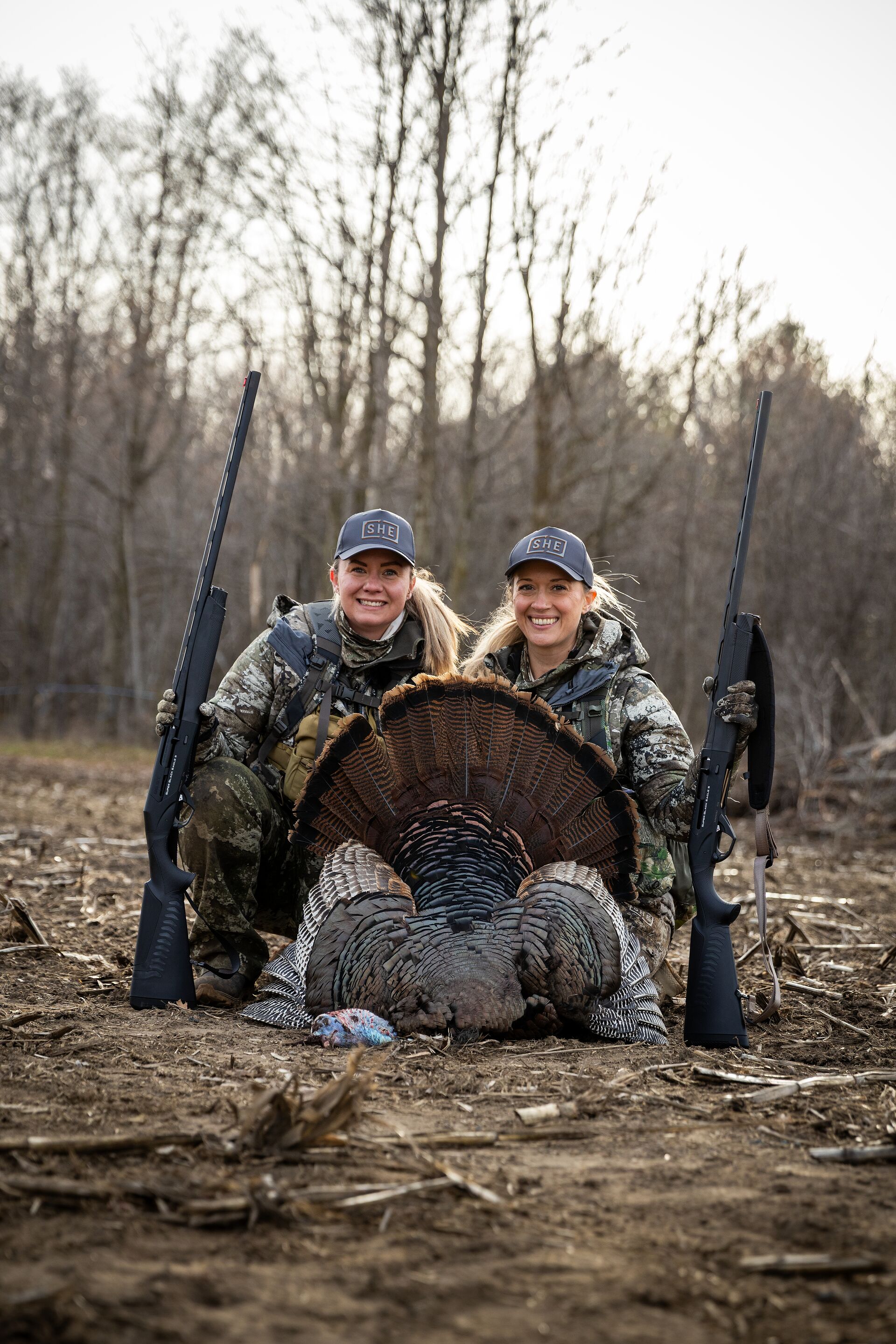 Two women with turkey and shotguns after hunt, how to get your Illinois hunting license concept. 