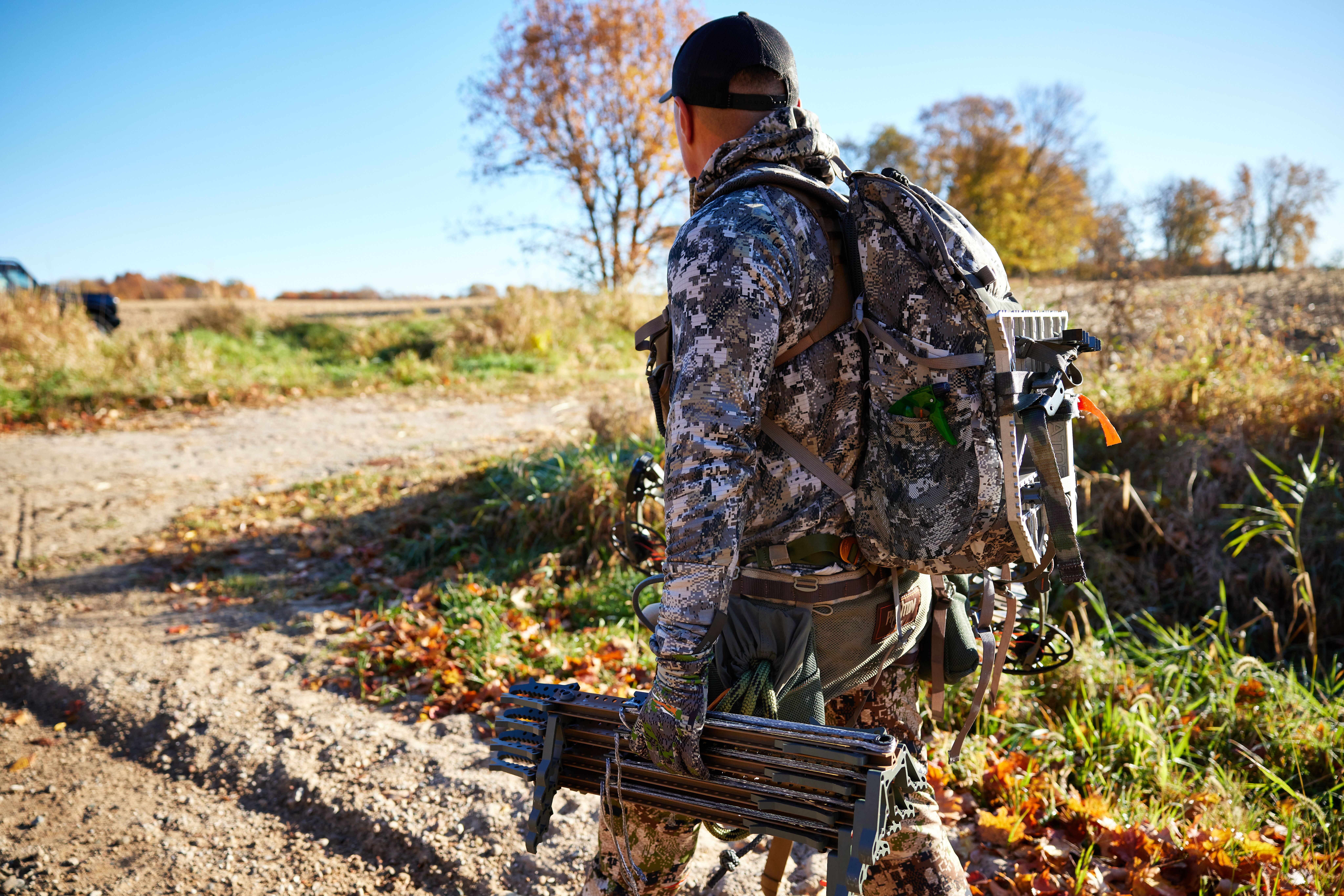 Hunter in camo with tree saddle gear, get an Arkansas hunting license concept. 