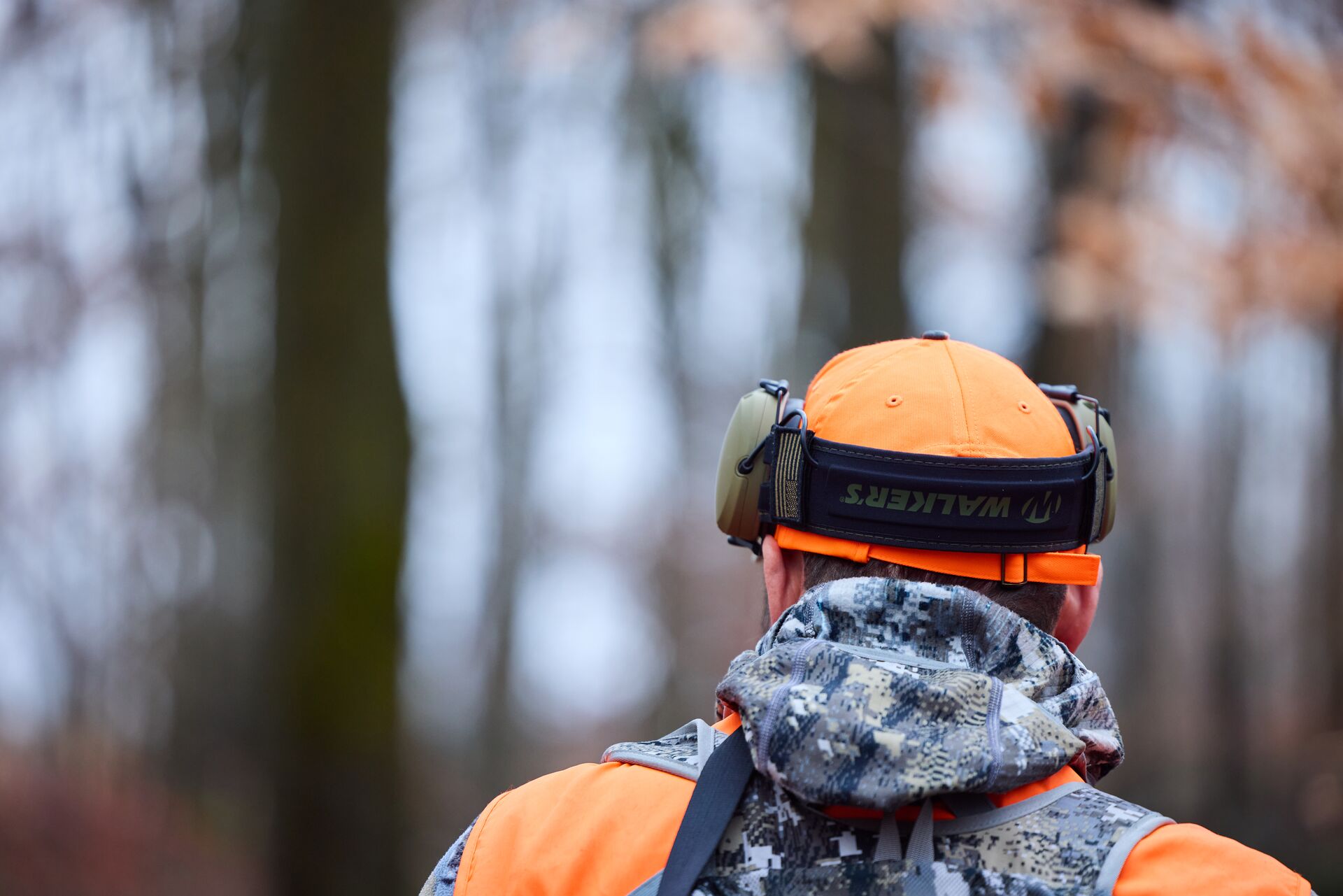 Close-up of hunter in orange with ear protection, field day requirements by state concept.