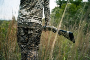 Back of hunter in camo with camo shotgun, how to get a hunting license concept.